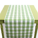 a green table covered by a Gin Lane Green Gingham Paper Table Runner on a white background