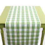 a green table covered by a Gin Lane Green Gingham Paper Table Runner on a white background