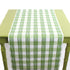 a green table covered by a Gin Lane Green Gingham Paper Table Runner on a white background