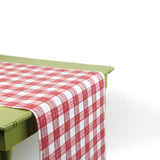 a green table covered by a Gin Lane Red Gingham Paper Table Runner on a white background