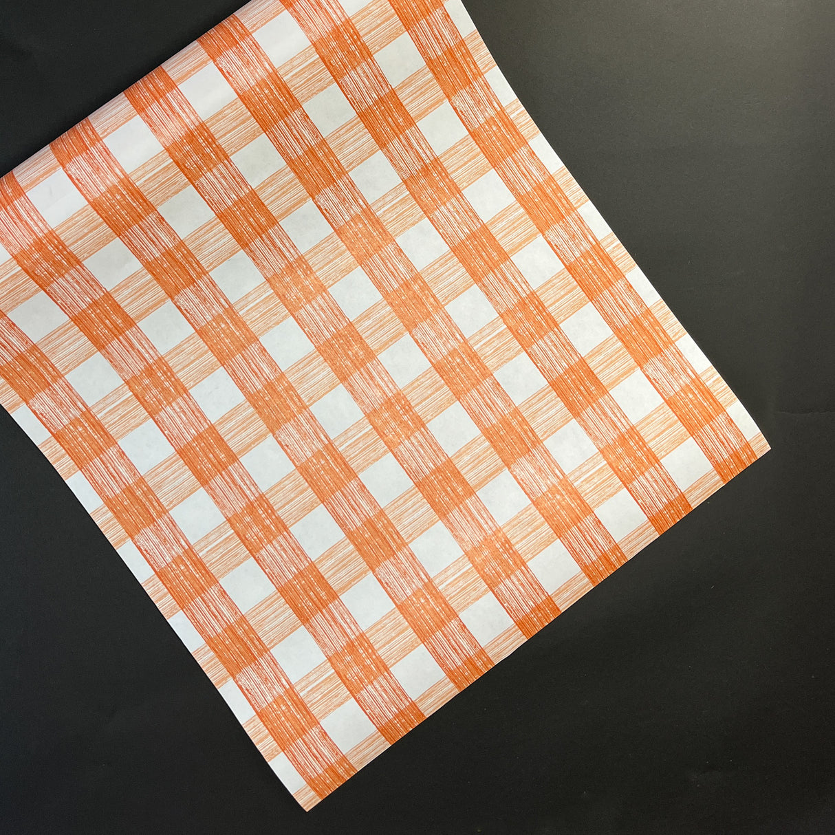 a gingham orange paper table runner in a pattern called gin lane by madcap cottage
