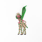 Decorative giraffe ornament with green spots and a pink bow on a white background