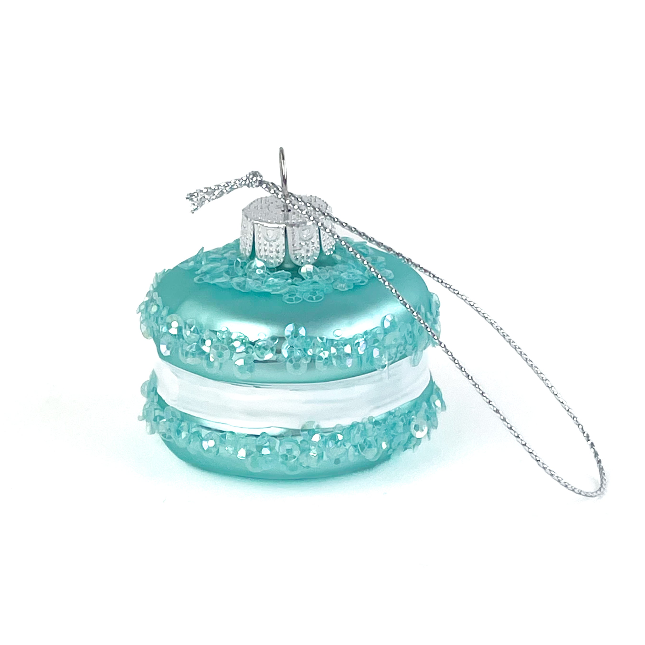 Turquoise macaron ornament with a silver chain on a white background