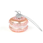 Pink glass macaron ornament with silver chain on a white background