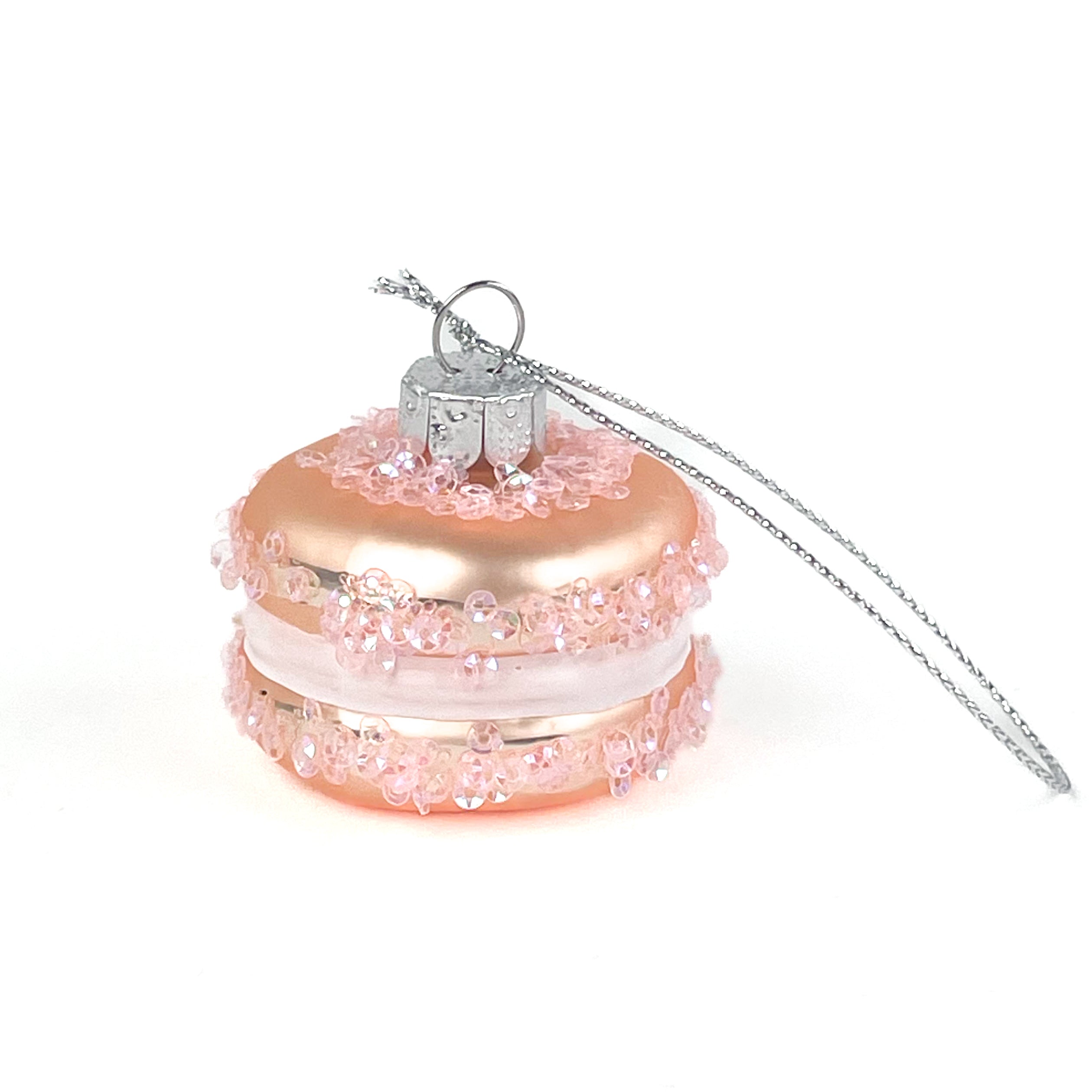 Pink glass macaron ornament with silver chain on a white background