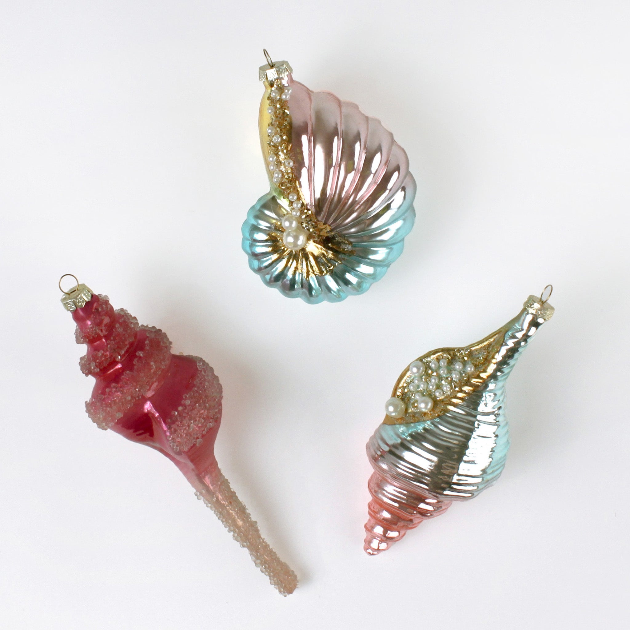 Three decorative glass shell ornaments on a white background