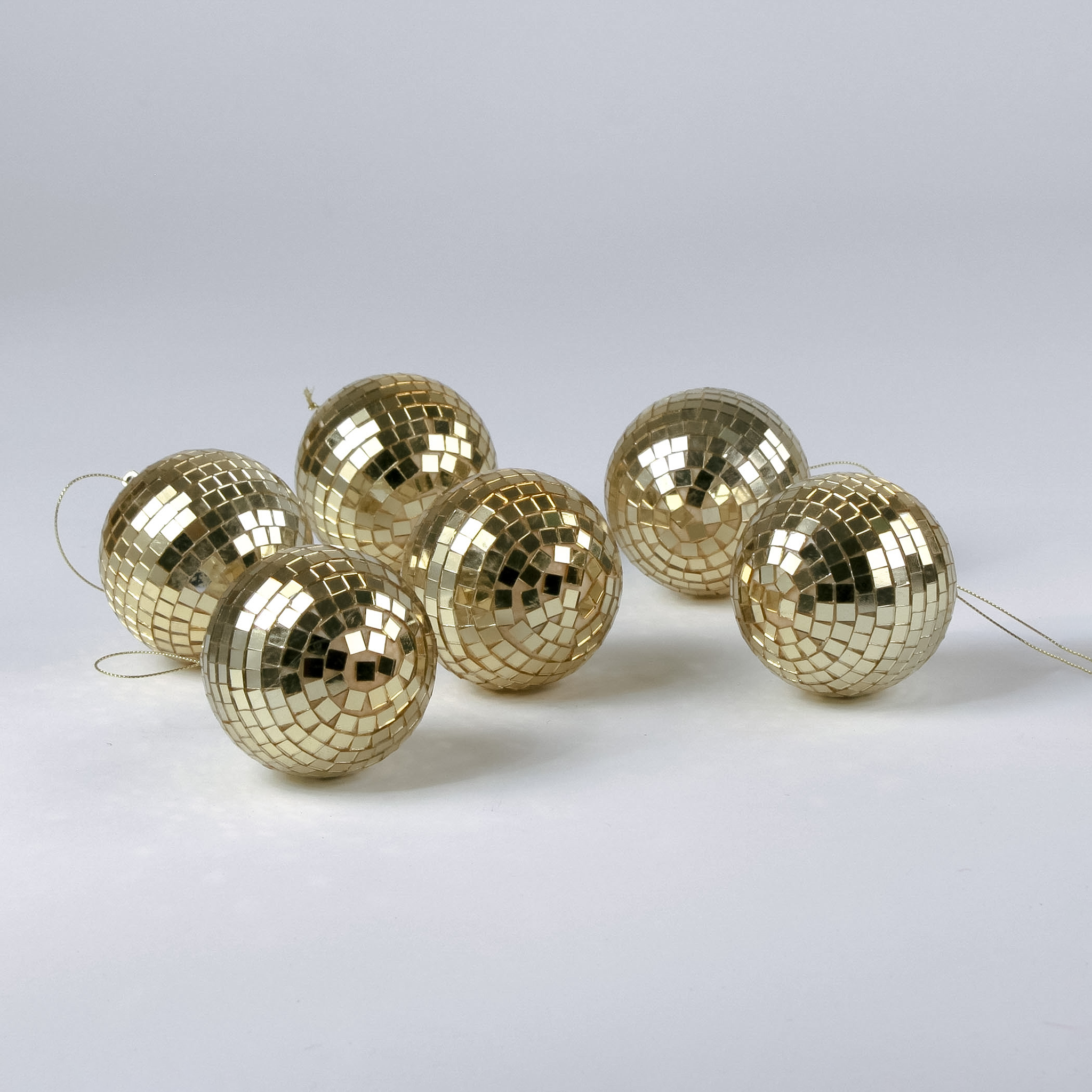 six mini gold disco ball ornaments on a white background