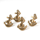 four metal anchor napkin rings on a white background. 