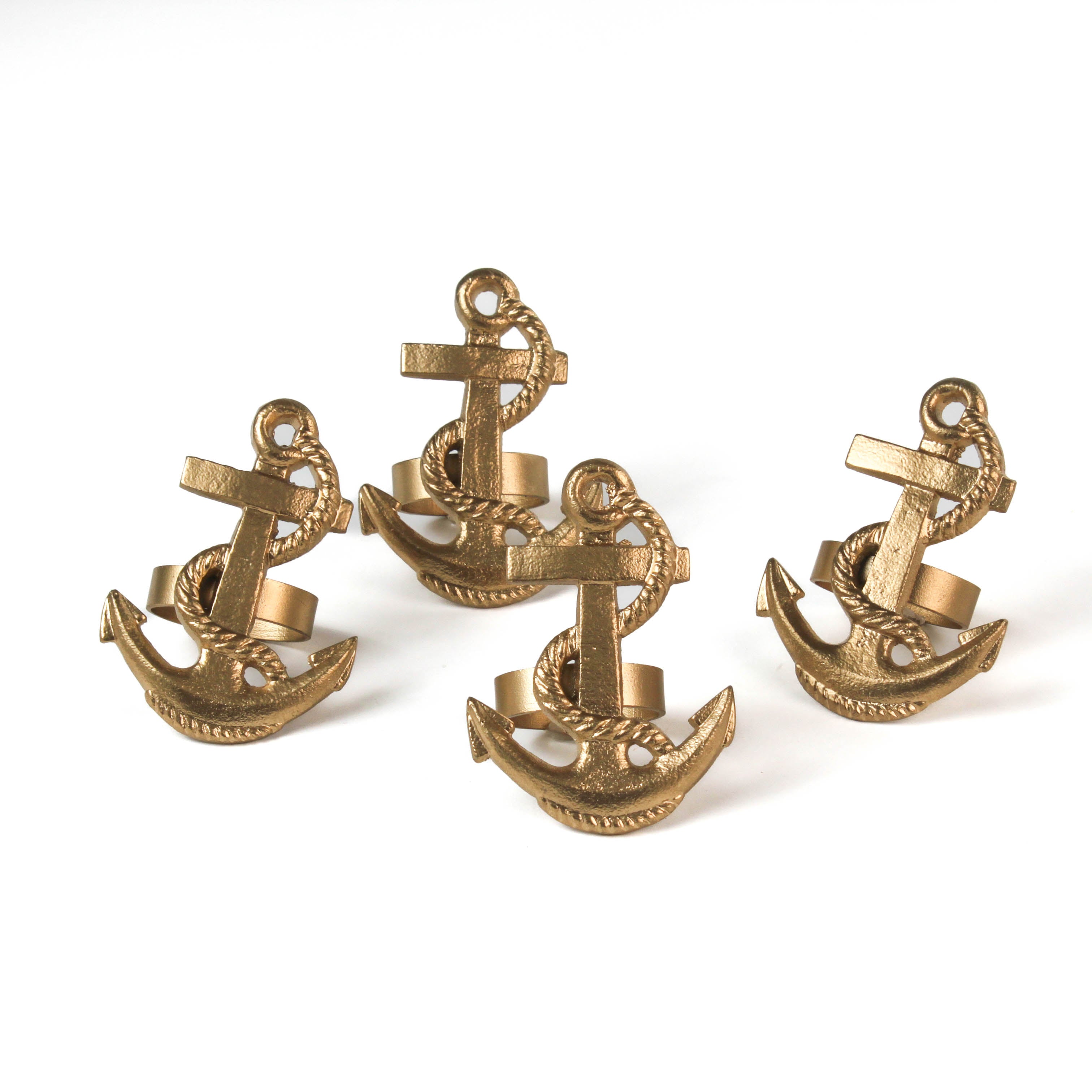 four metal anchor napkin rings on a white background. 