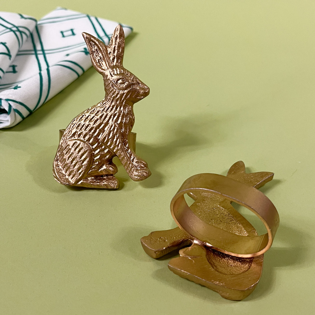 Pair of gilt metal bunny napkin rings with one showing ring and backside detail