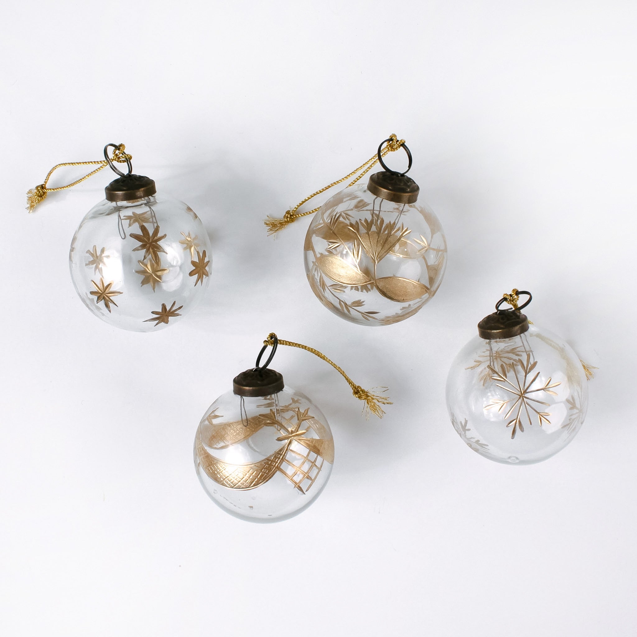 Set of 4 clear glass Christmas ornaments with elegant gold leaf and star designs, featuring gold hanging cords — perfect for adding a touch of luxury to holiday décor.