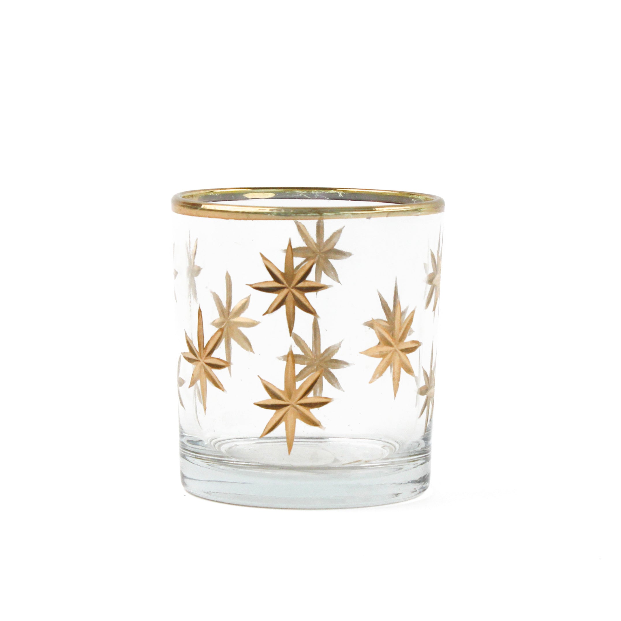 Clear glass candle holder with gold star designs on a white background