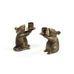 Two gold mouse candle holders on a white background
