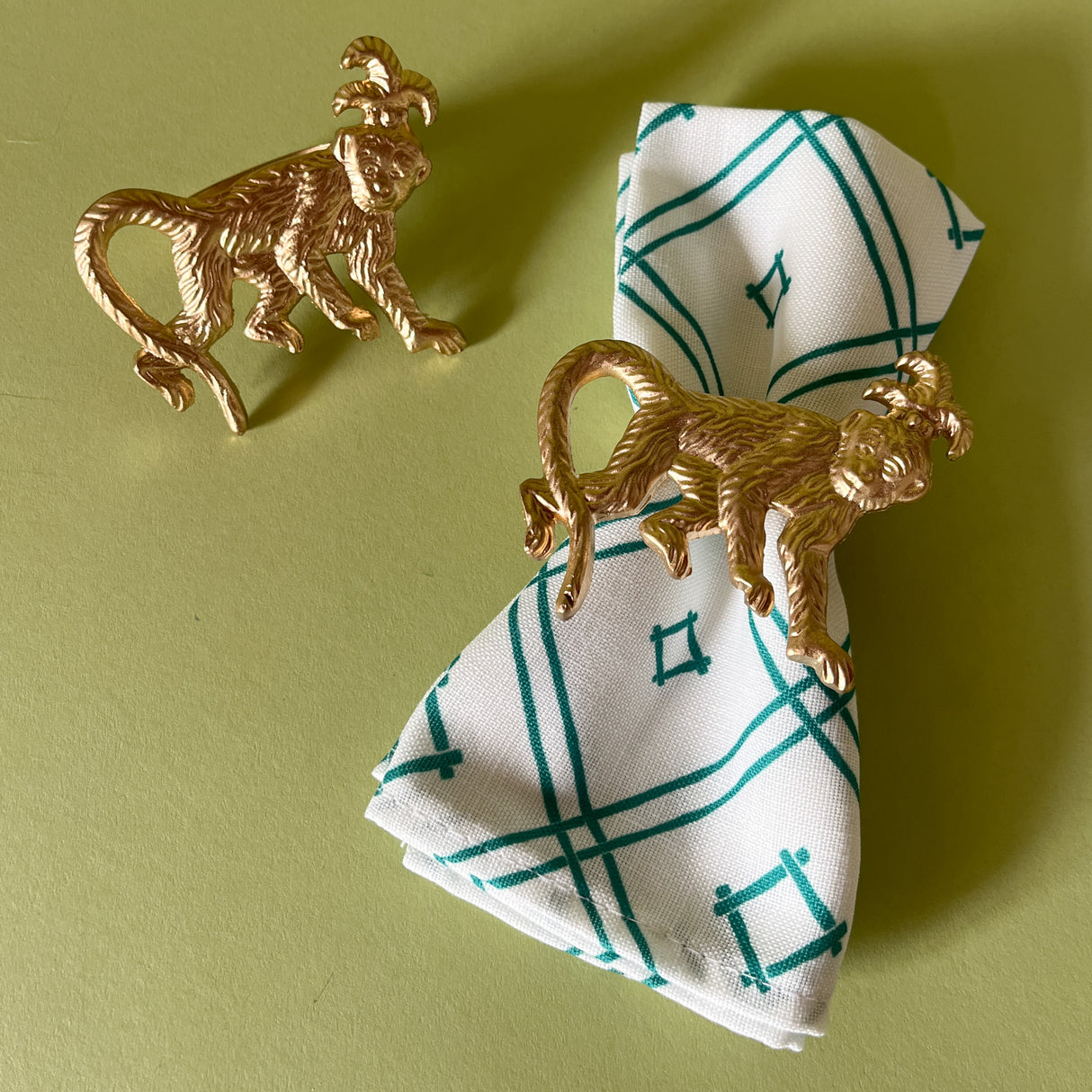 gilt metal monkey napkin ring pair with one on a dinner napkin