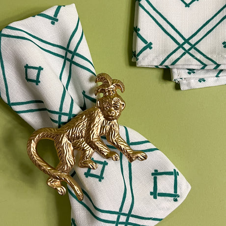 gilt metal monkey napkin ring on a white and green dinner napkin