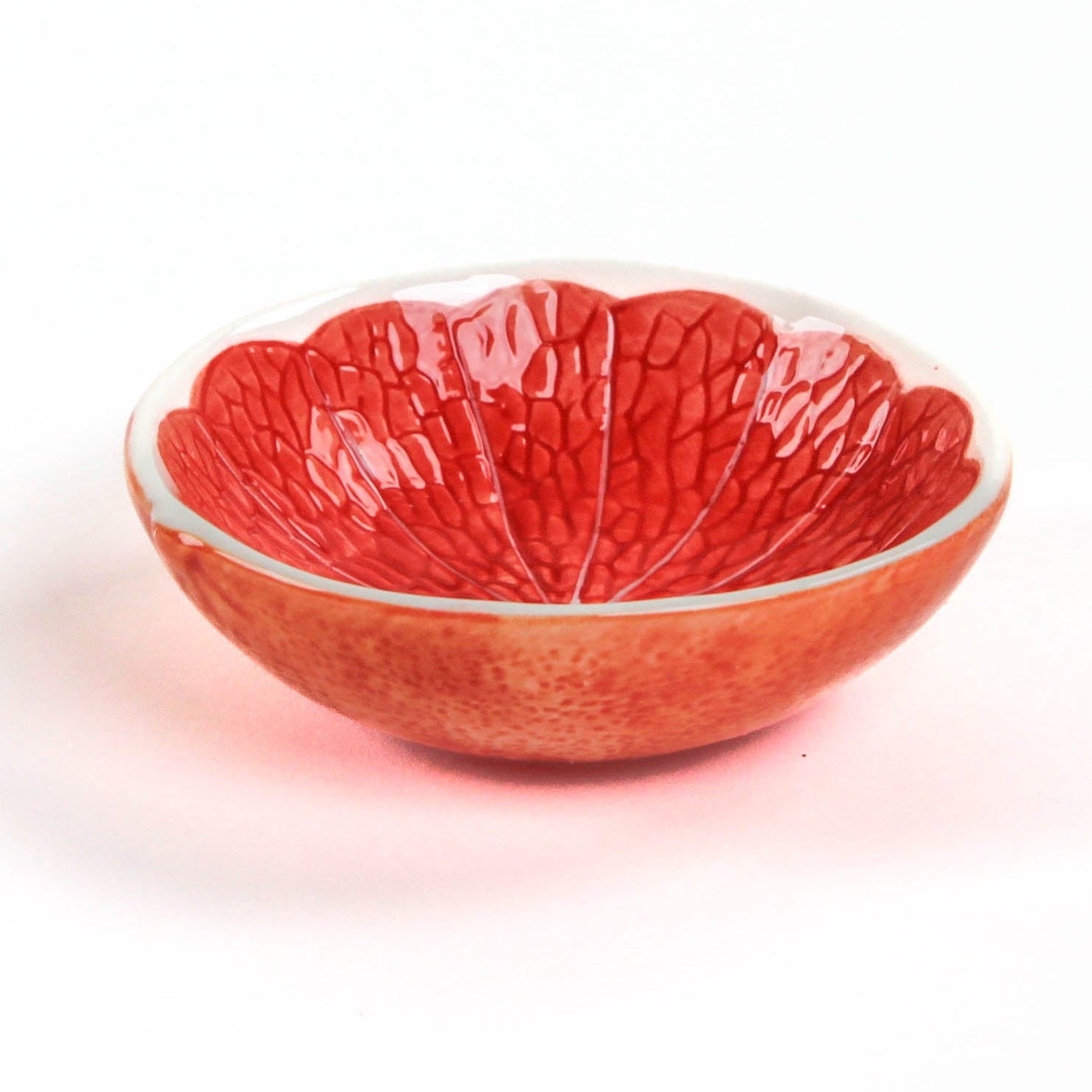 grapefruit shaped ceramic bowls with a textured surface on a white background