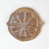 citrus fruit shaped ceramic plate with decorative citrus pattern on a white background