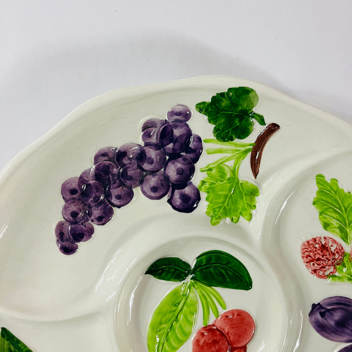 A white vintage strawberry pitcher with strawberry motifs decorating the side