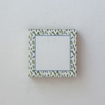 a square luxury notepad with green brushstroke pattern border outlined with blue. 