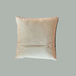 reverse back of a square decorative pillow with a hooked texture, featuring a white pug with green details surrounded by pink, white, and green floral accents on a blush pink background.