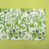 a green and white cloth table runner in a  bunny and bow print fabric