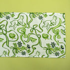 a green and white cloth table runner in a  bunny and bow print fabric