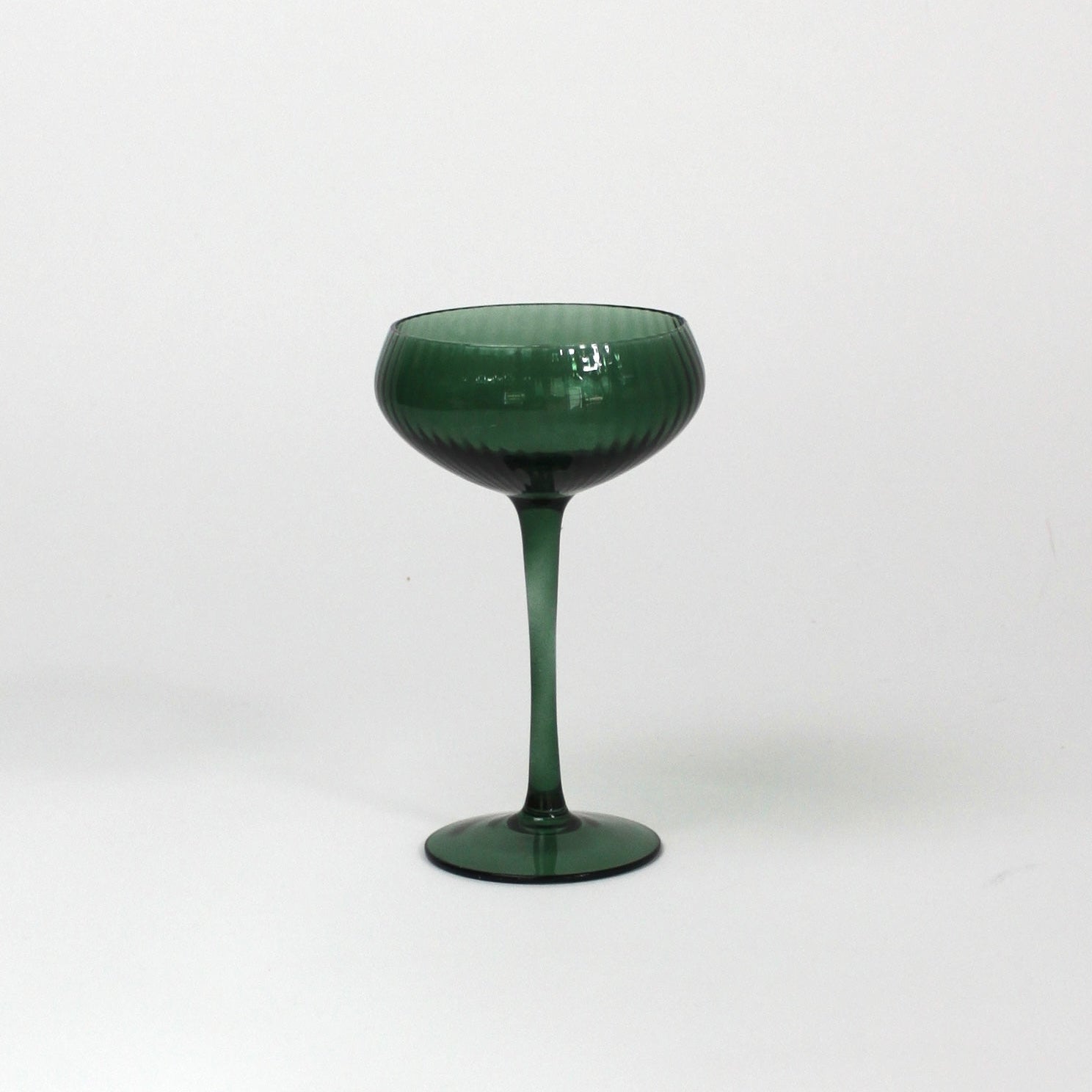a green coupe glass on a white background from madcap cottage