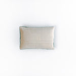 back of a rectangular green decorative pillow with a hooked texture, featuring two crossed golf clubs and a small white golf ball in the center.