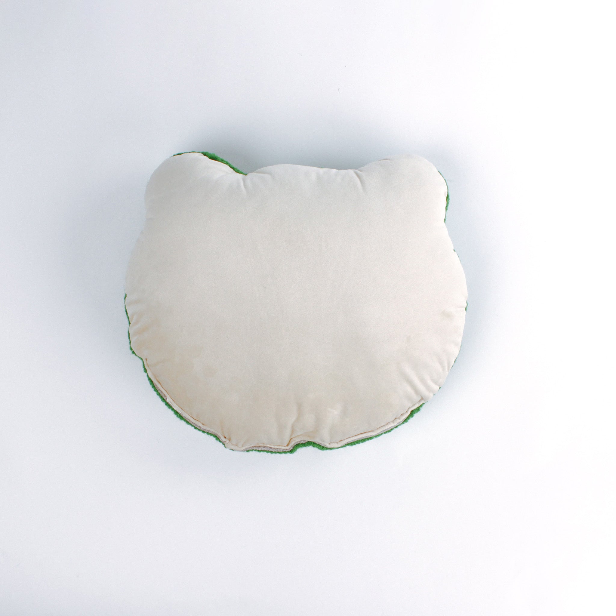 reverse back of a Frog-shaped decorative pillow with a hooked texture, featuring a smiling green frog face with pink cheeks and large black eyes.