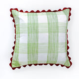 Square decorative pillow with a light green gingham plaid pattern on a white background, finished with a red scalloped trim around the edges.