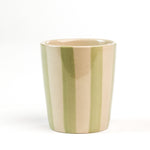 A green striped ceramic cup in on a white background. 