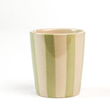 A green striped ceramic cup in on a white background. 