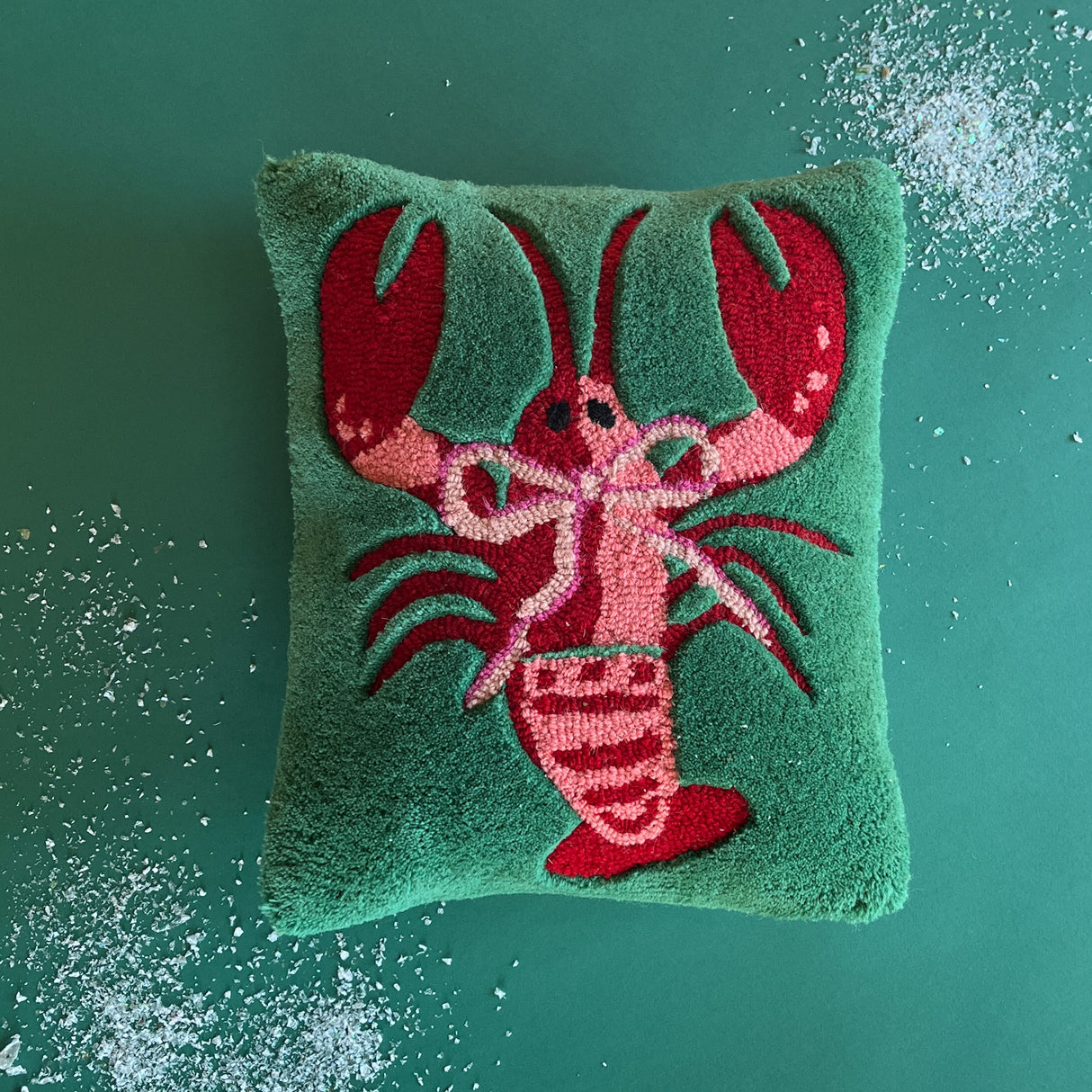 a green pillow with a large lobster motif