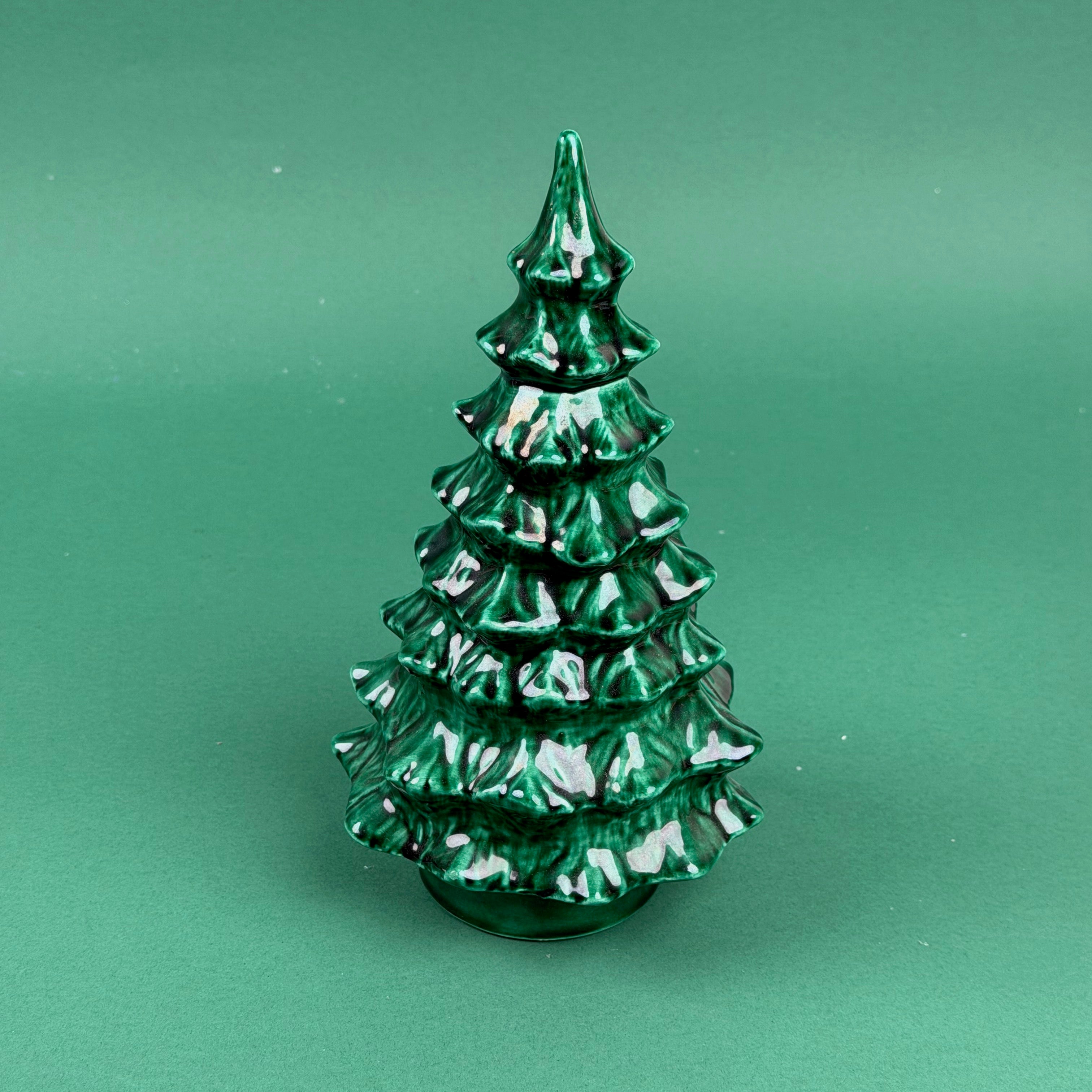 Green marbled Christmas tree ornament on a solid green background
