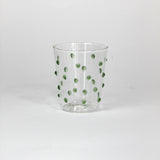 Clear glass with green polka dots on a white background