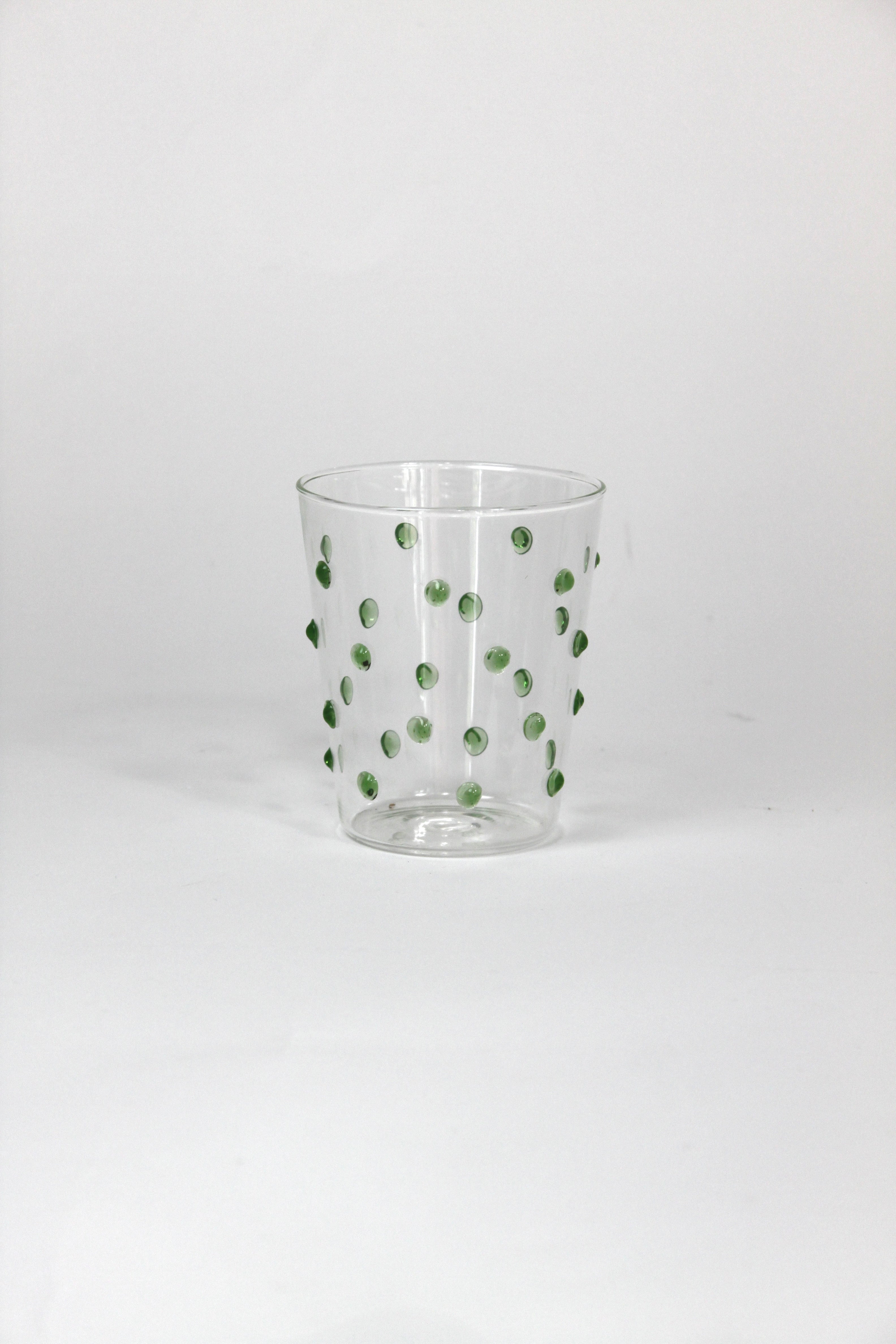 Clear glass with green polka dots on a white background