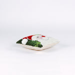 side of a Square Christmas pillow featuring a hooked wool design of Santa Claus with rosy cheeks, a red hat, and green holly leaves on a dark green background.