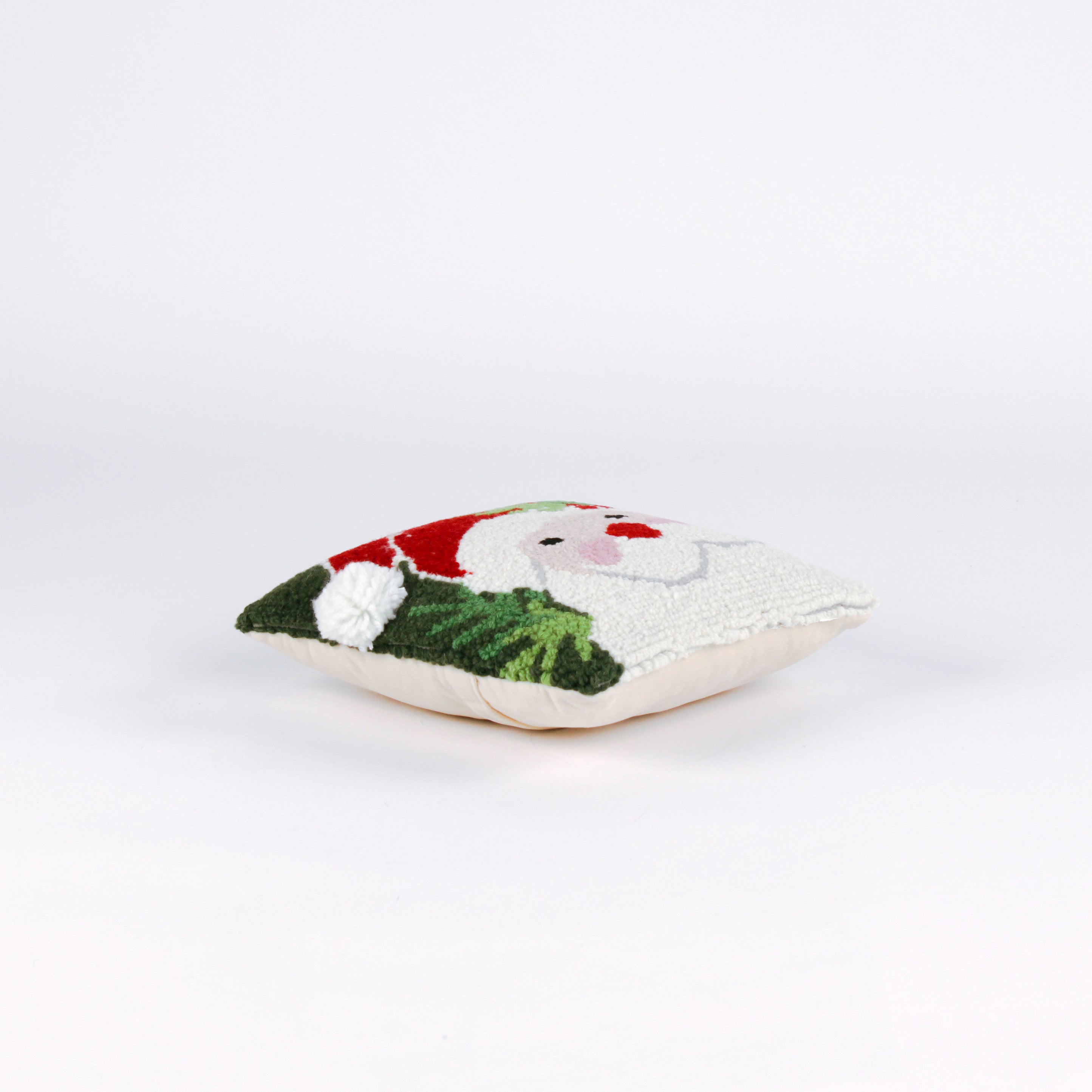 side of a Square Christmas pillow featuring a hooked wool design of Santa Claus with rosy cheeks, a red hat, and green holly leaves on a dark green background.