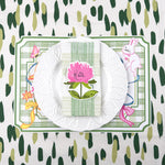 spring Easter paper placemat table setting with white plate, green striped napkin, and floral place card.