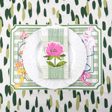 spring Easter paper placemat table setting with white plate, green striped napkin, and floral place card.