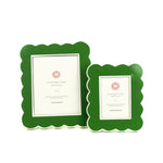 Two green scalloped photo frames with white backgrounds on a white background