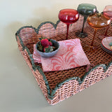 green rattan serving tray styled with champagne glasses side detail