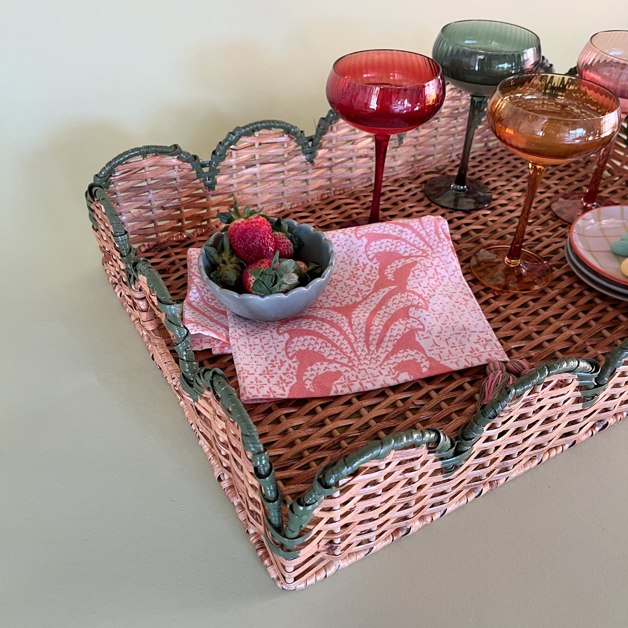 green rattan serving tray styled with champagne glasses side detail