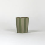 A green striped ceramic cup in on a white background. 