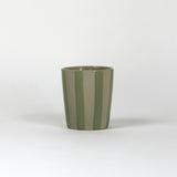 A green striped ceramic cup in on a white background. 