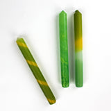 3 yellow and green assorted taper candles in white background