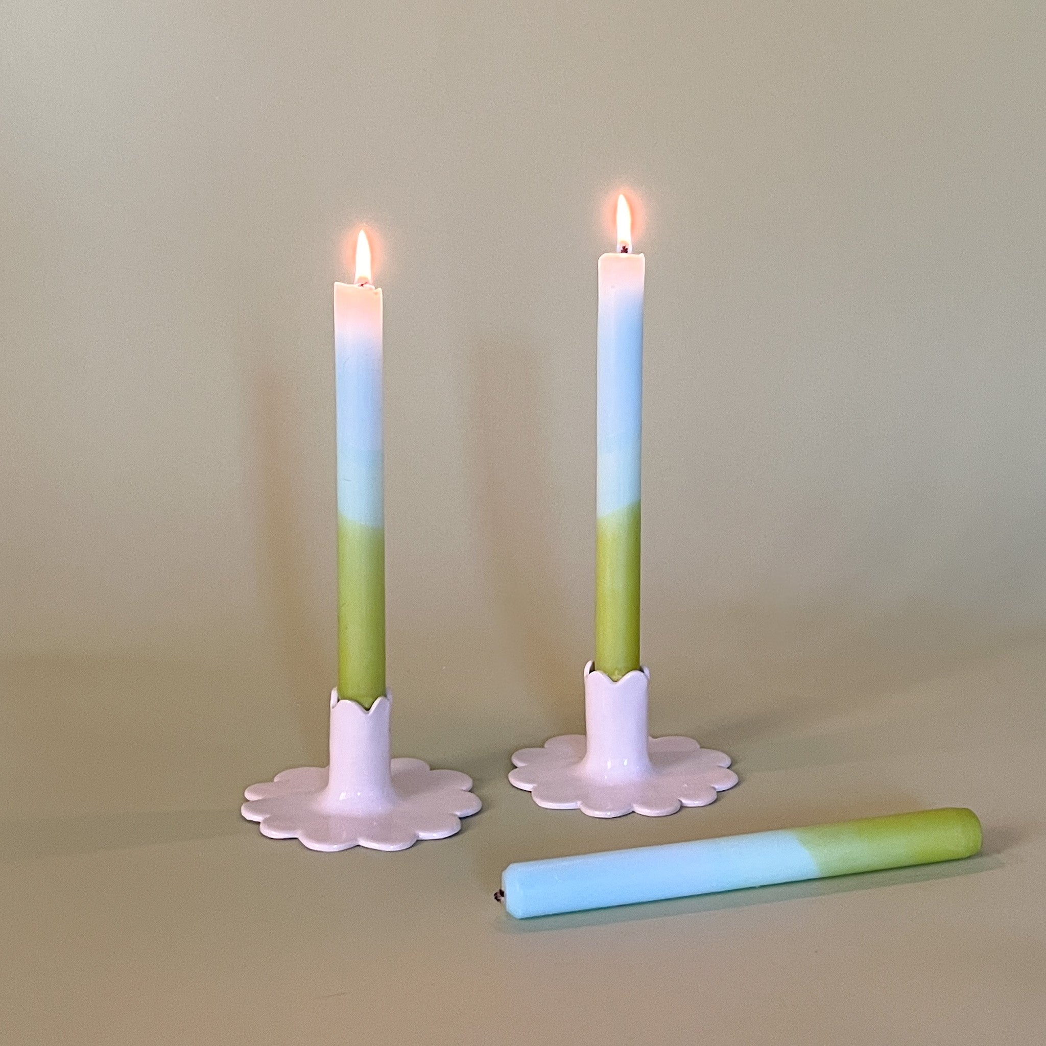 blue and green taper candles in white scalloped candle holders