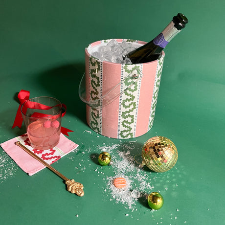 a pink ice ice bucket filled with ice and a champage bottle. 