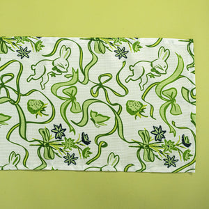 a green and white  table runner and napkin in a  bunny and bow print fabric. 