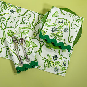 a green and white  table runner and napkin in a  bunny and bow print fabric. 